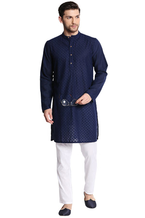 Man wearing a navy kurta with white pants on a white background
