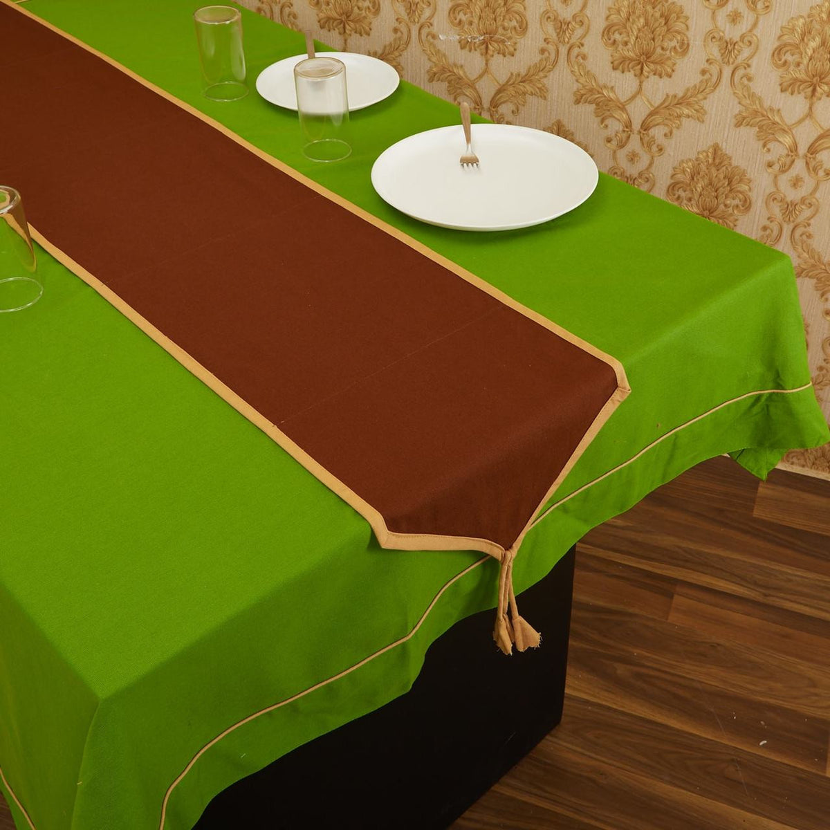 Brown In-Sattva solid cotton fringe table runner styled with white place settings on a green table