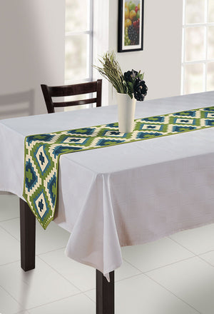 In-Sattva green bohemian print cotton table runner styled on a white dining table with a vase centerpiece