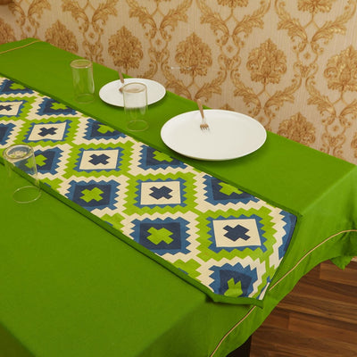 Green In-Sattva bohemian print table runner styled with white place settings on a green dining table