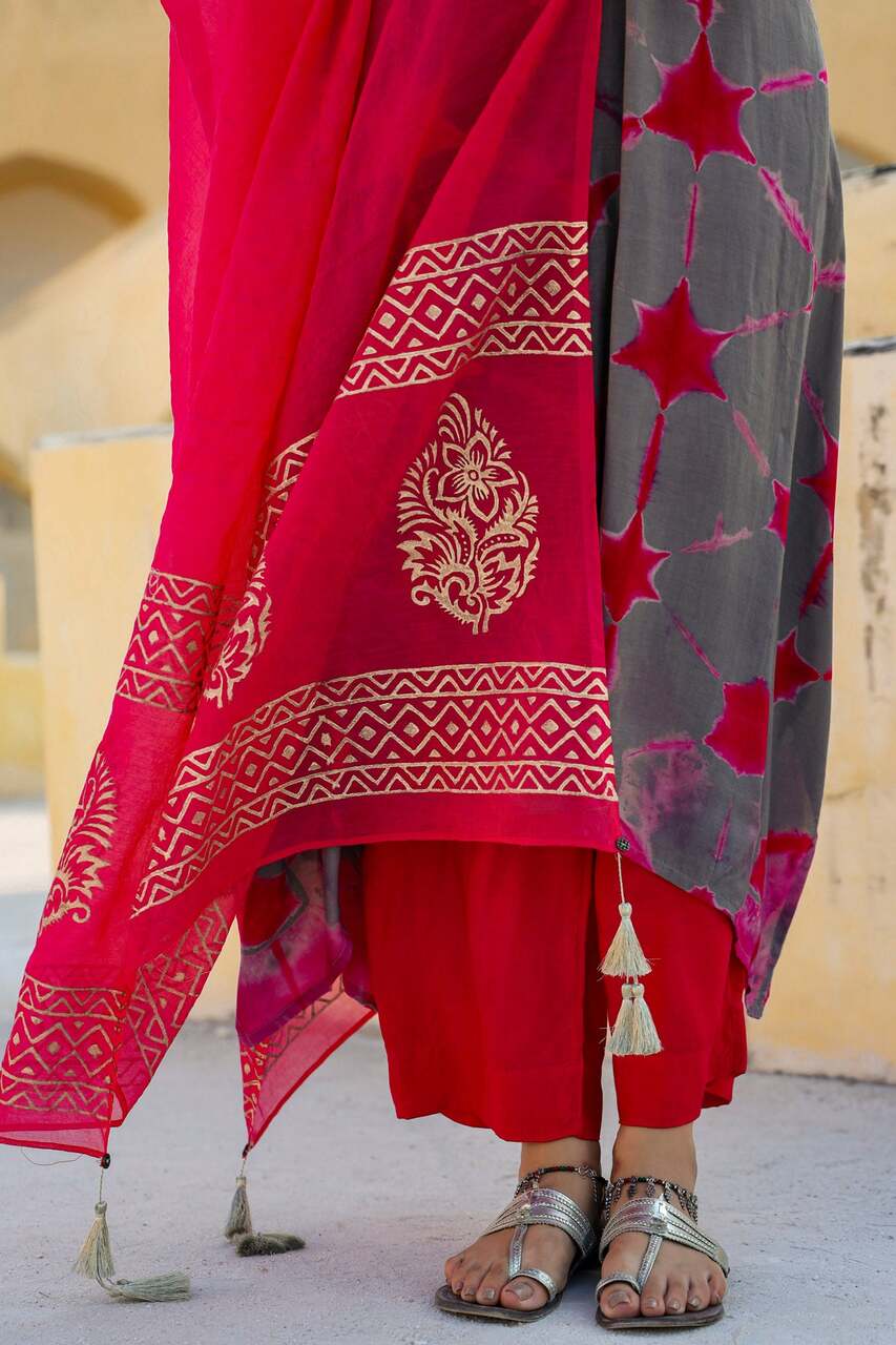 Close-up of a In-Sattva magenta dupatta with gold block print, patterned border and tassel detailing