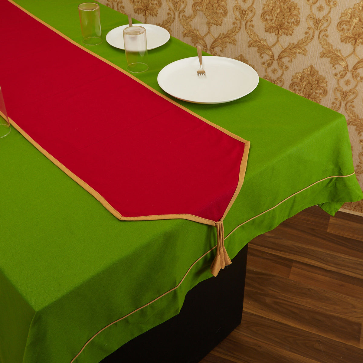 Maroon In-Sattva solid cotton fringe table runner styled with white place settings on a green table