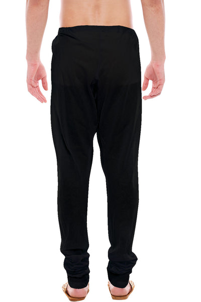 Back view of In-Sattva men's black cotton churidar pants, showing the tapered full-length fit and ankle gathers from the back.