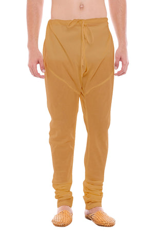 Front view of In-Sattva men's gold art silk churidar pants, showing the drawstring waist, tapered legs and ankle gathers.