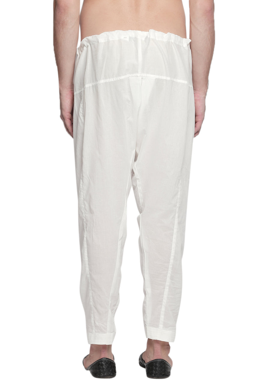 Back view of In-Sattva men's off-white cotton baggy salwar yoga pants, showing the roomy seat and tapered-leg shape from the back.