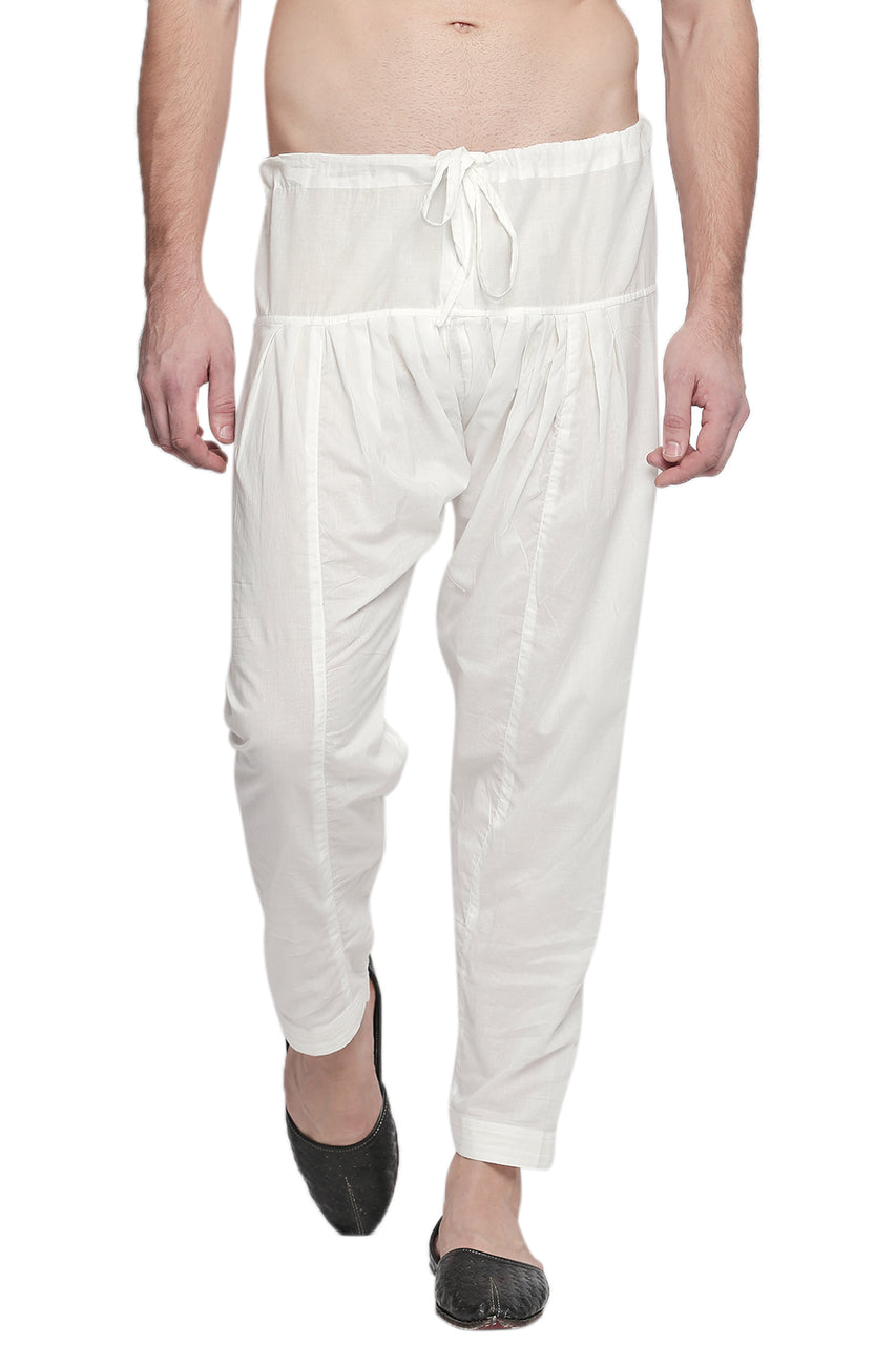 Front view of In-Sattva men's off-white cotton baggy salwar yoga pants, showing the drawstring waistband, roomy hips and tapered ankles.