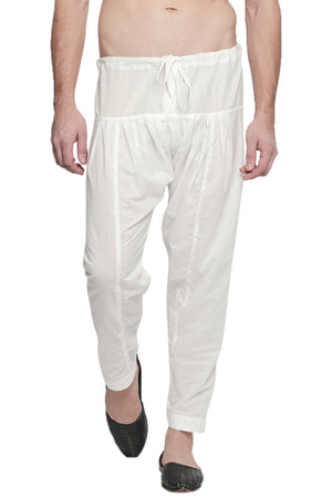 Front view of In-Sattva men's off-white cotton baggy salwar yoga pants, showing the drawstring waistband, roomy hips and tapered ankles.