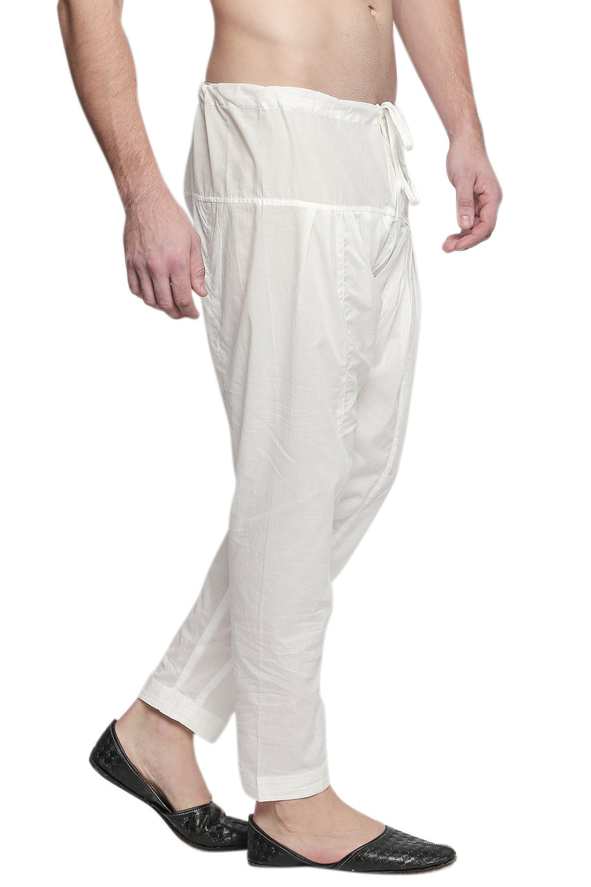 Right profile view of In-Sattva men's off-white cotton baggy salwar yoga pants, showing the baggy hip shape narrowing into the tapered ankle.