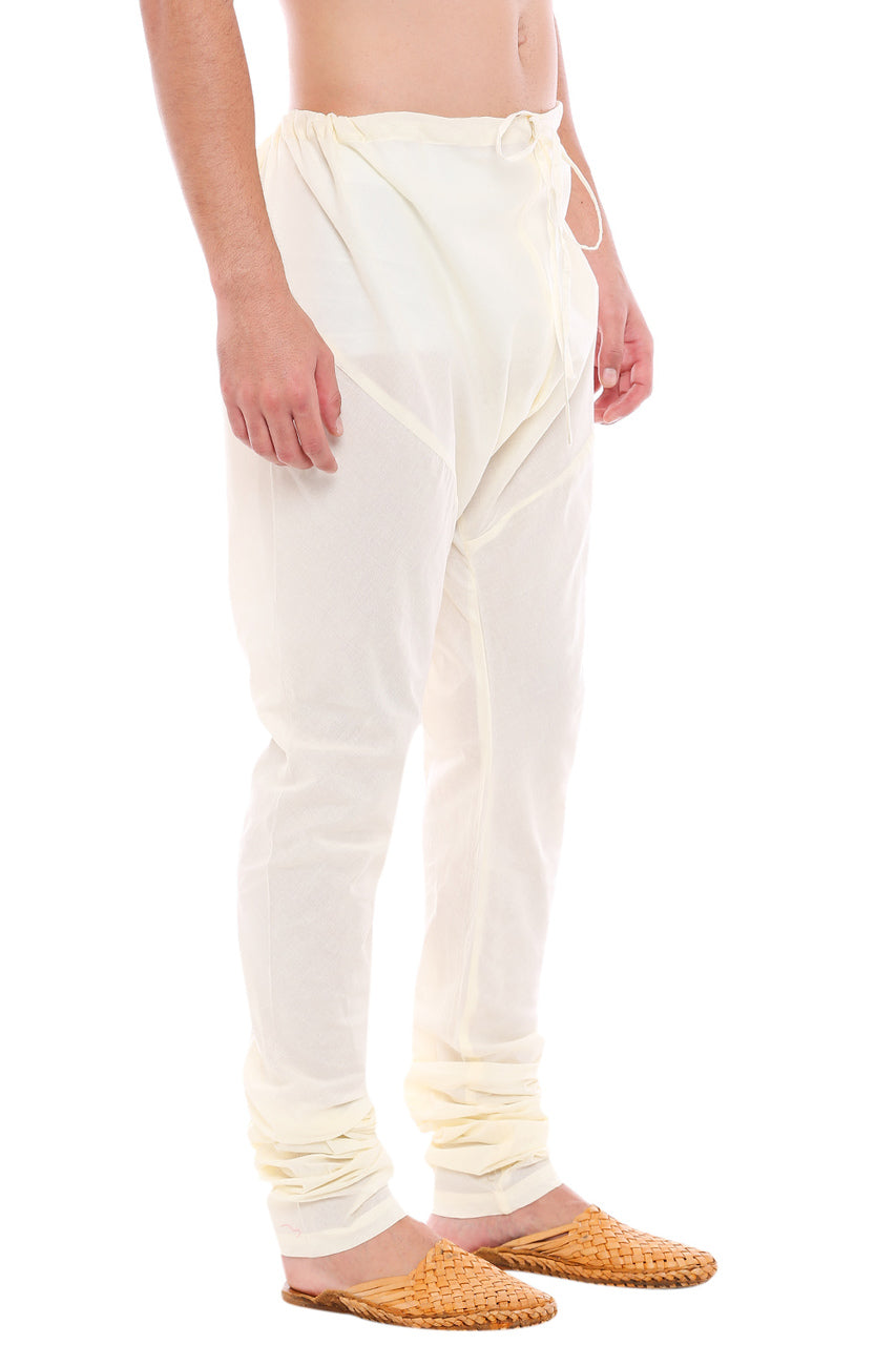 Left profile view of In-Sattva men's off-white cotton churidar pants, showing the smooth cotton profile and gathered ankle fit.