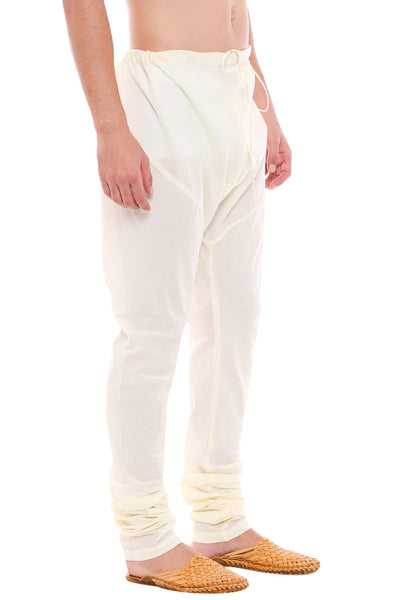 Left profile view of In-Sattva men's off-white cotton churidar pants, showing the smooth cotton profile and gathered ankle fit.