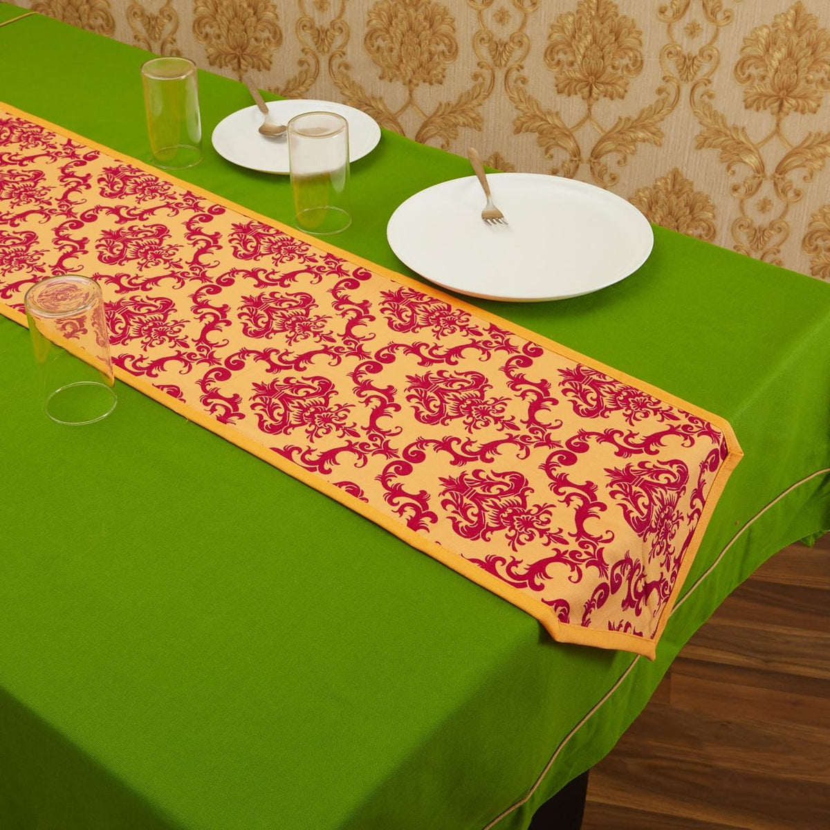 Rust In-Sattva bohemian print cotton table runner styled with white place settings on a green table