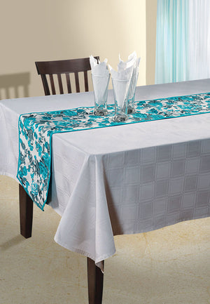 In-Sattva teal bohemian floral print cotton table runner styled on a white dining table with glassware