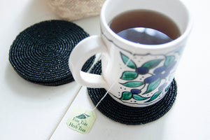 Rangeene black glass beaded round coaster styled with a floral coffee mug