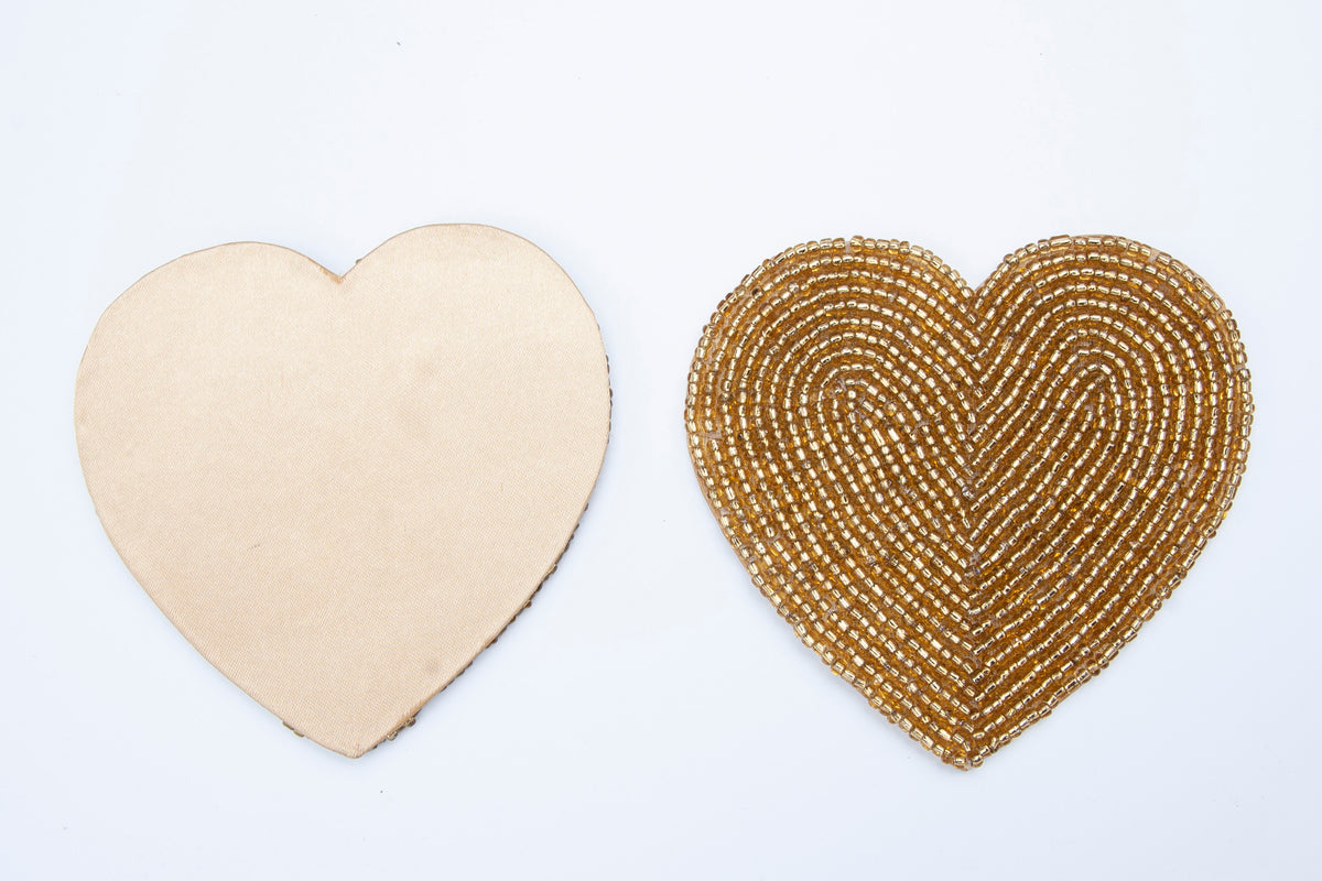 Front and non-slip back of a Rangeene gold glass beaded heart shaped coaster