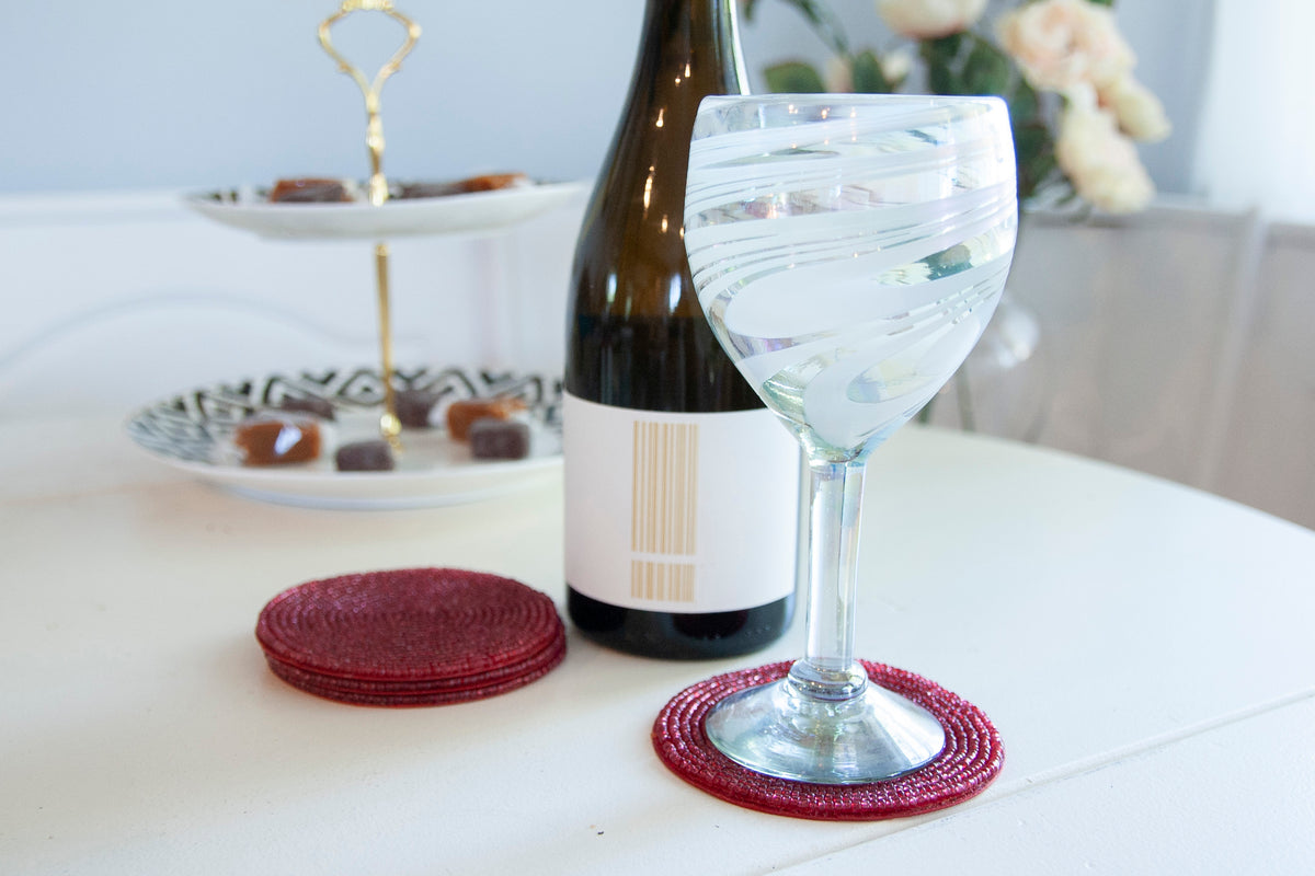 Rangeene red glass beaded round coaster styled beneath a wine glass