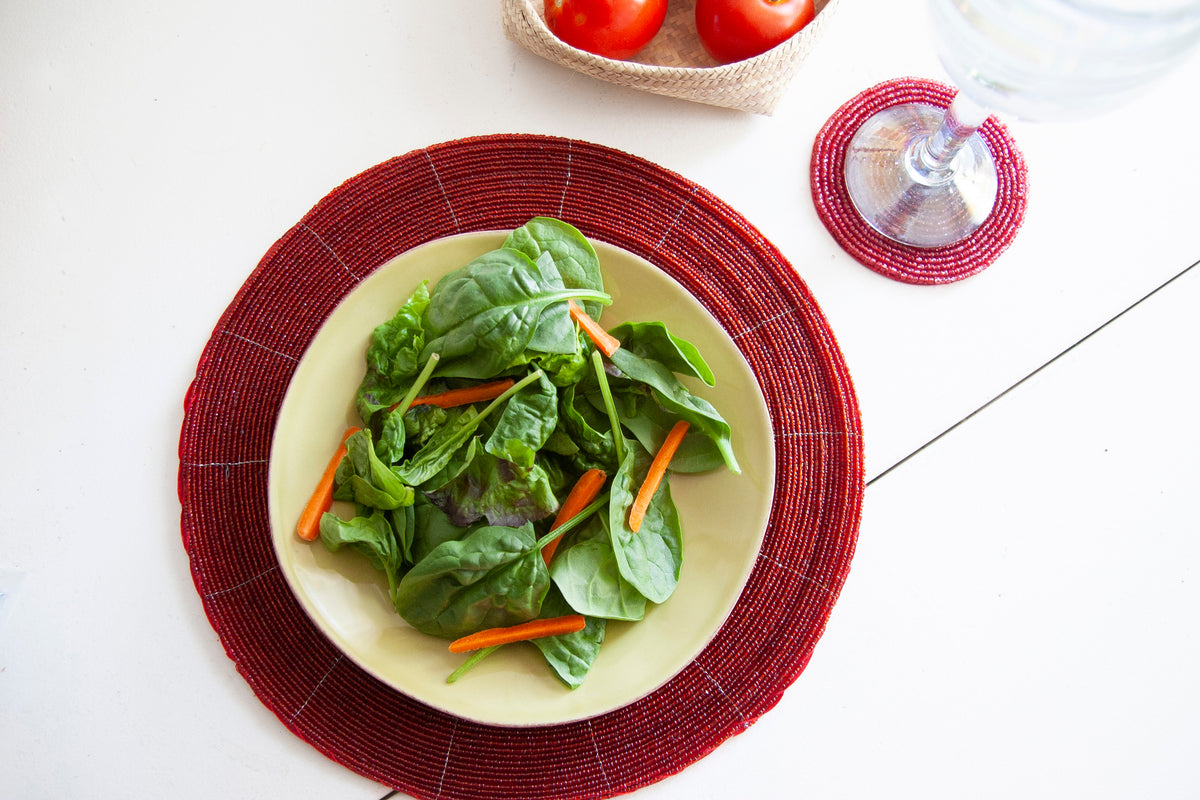 Overhead dining setting with a salad plate on a Rangeene red glass beaded placemat