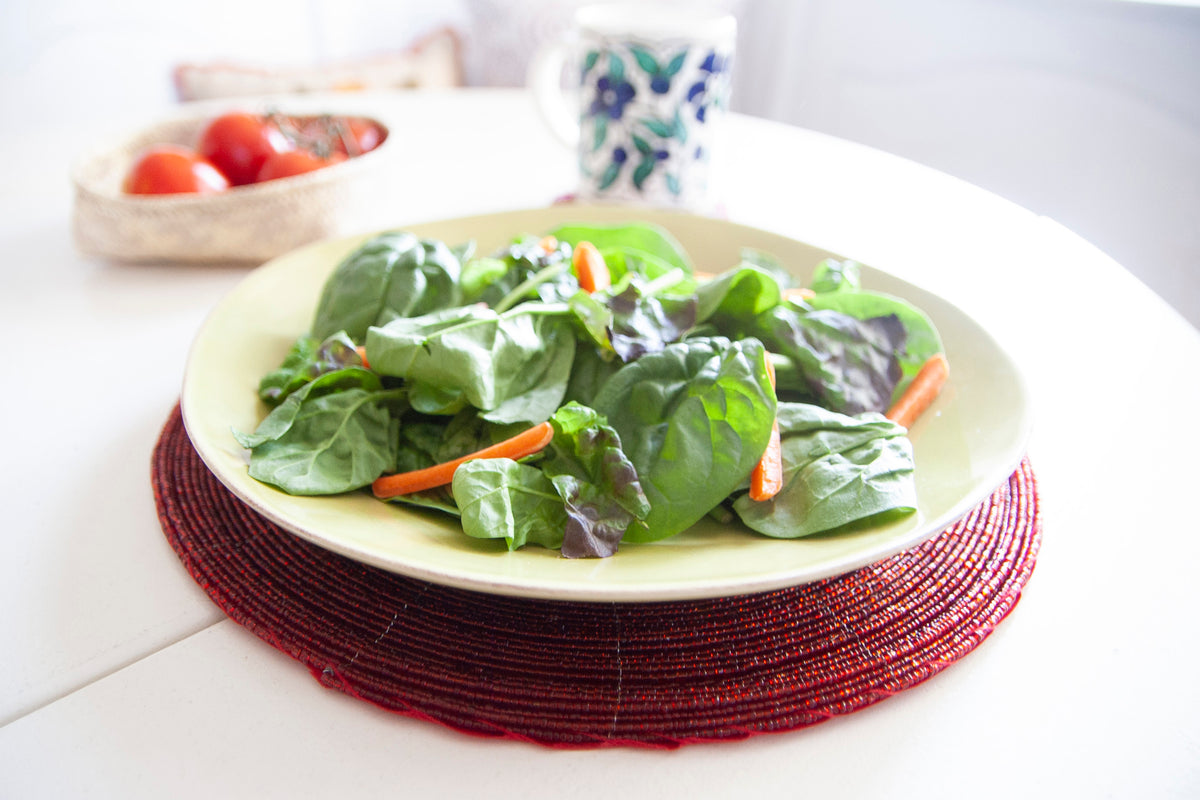 Salad plate displayed on a Rangeene red handmade glass beaded round placemat