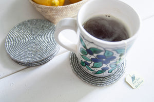 Rangeene silver glass beaded round coaster styled with a floral coffee mug