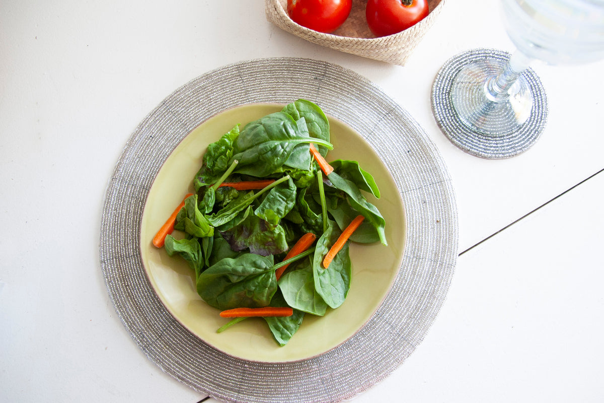 Overhead dining setting with a salad plate on a Rangeene silver glass beaded placemat