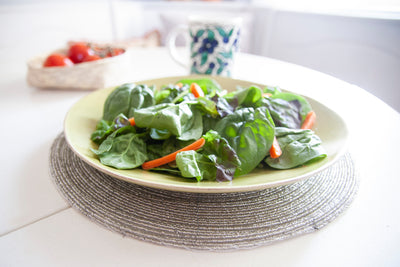 Salad plate displayed on a Rangeene silver handmade glass beaded round placemat