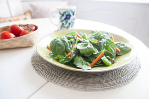 Dining table styled with a salad plate on a Rangeene silver glass beaded round placemat