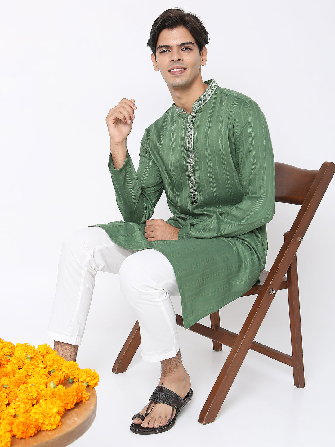 Men's green embroidered cotton knee-length kurta, fabric texture detail.