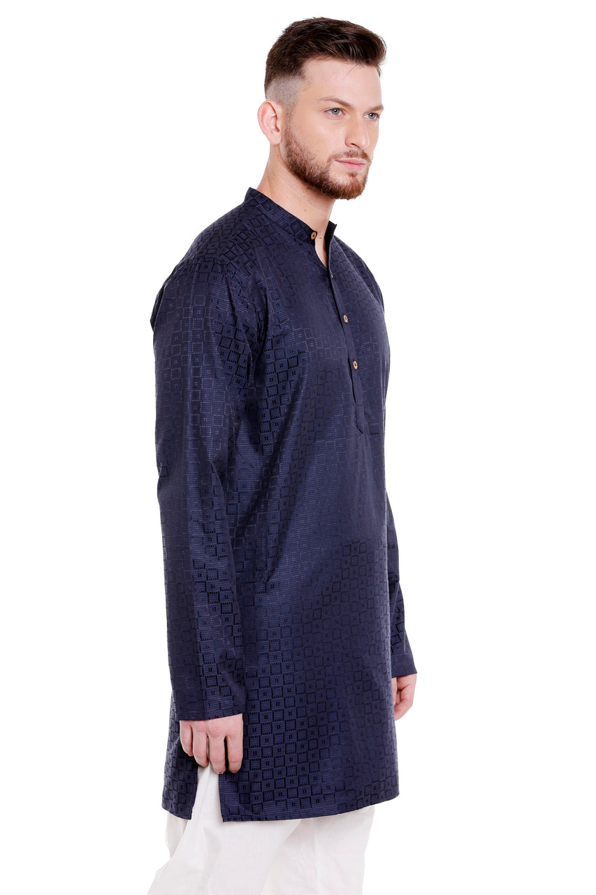 Side view of a model wearing In-Sattva's men's royal blue Indian cotton kurta tunic, featuring a dobby check pattern, band collar, long sleeves and button placket. The side slit is visible.